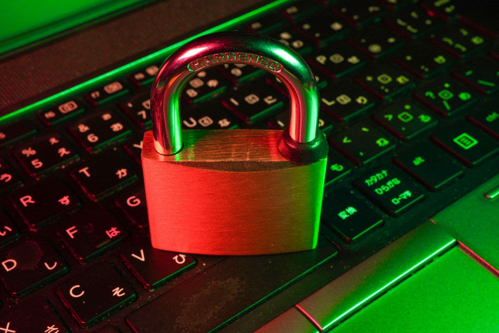 A brass padlock resting on a laptop keyboard lit in red and green, standing in for a scoped API key